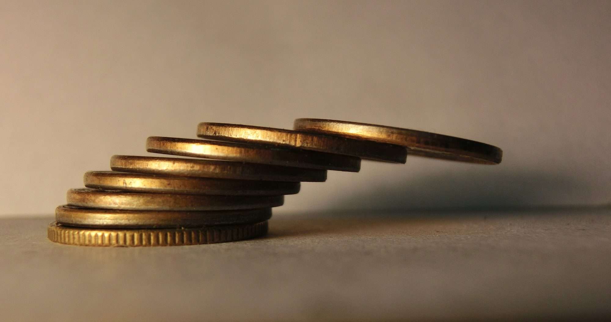 Monedas doradas apiladas una sobre otra, cada una un poco desplazada respecto a la de abajo