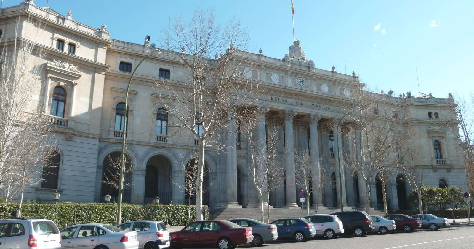 Fachada del Palacio de la Bolsa de Madrid con coches aparcados delante
