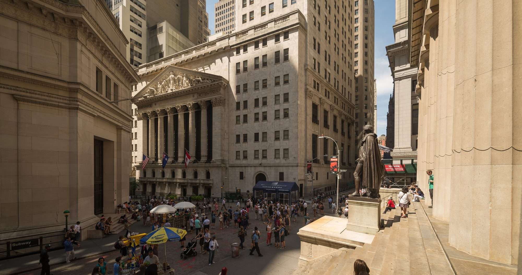 Cruce de Wall Street y Broad Street con el edificio de la Bolsa de Nueva York al fondo y mucha gente en la calle